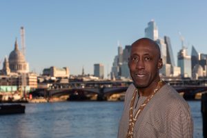 Photo of site owner Fitzroy Andrew. The location is the South Bank, close to the River Thames. The out of focus background features buildings against the London skyline, the most famous of which is St Paul's Catherdral