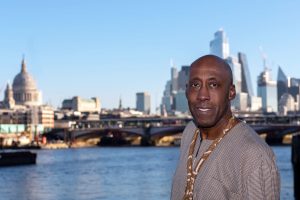 Photo of site owner Fitzroy Andrew in the foreground. The location is the South Bank, close to the River Thames. The out of focus background features buildings against the London skyline, the most famous of which is St Paul's Catherdral
